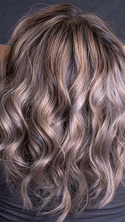 Woman with a cold dark to blonde ombre and warm blonde hightlights